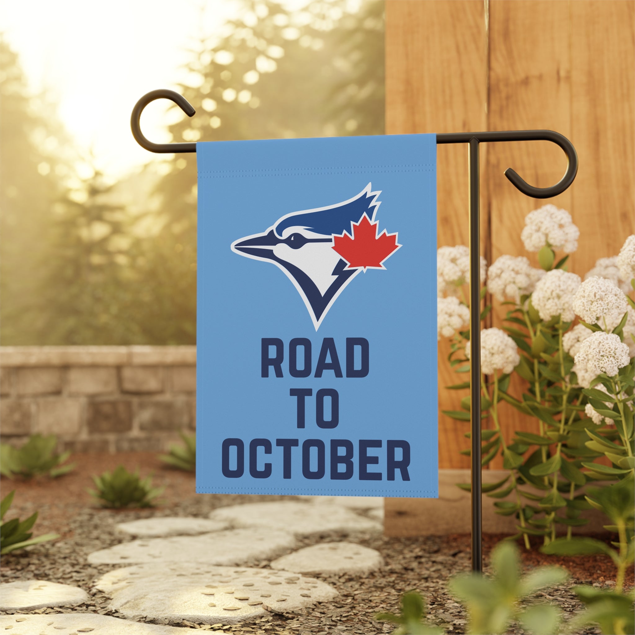 Garden flag with sports team logo and 'Road to October' text on a stand outdoors.